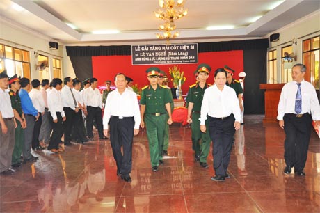Ông Lê Thanh Hải và ông Trần Thế Ngọc đưa hài cốt Anh hùng LLVT nhân dân Lê Văn Nghề đến an táng tại khu mộ tiêu biểu - Nghĩa trang Liệt sĩ tỉnh.