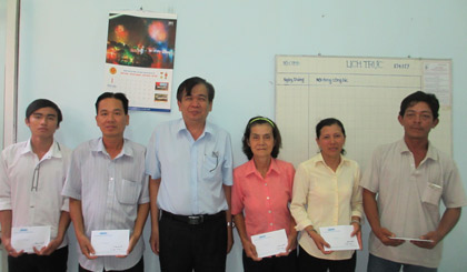 Ông Nguyễn Minh Tân, Phó Tổng Biên tập Báo Ấp Bắc trao học bổng cho sinh viên và đại diện gia đình. Ảnh: Ngọc Lệ