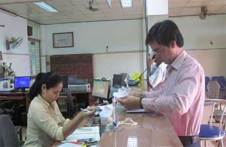 Khách hàng sử dụng dịch vụ bưu chính tại một điểm giao dịch của Bưu điện Tiền Giang.