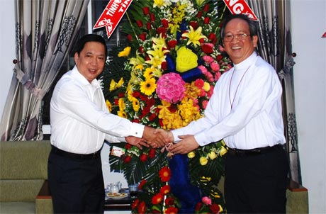 Bí thư Tỉnh ủy Trần Thế Ngọc trao hoa chúc mừng Giáng sinh đến đức Tổng Giám mục Phó Bùi Văn Đọc.