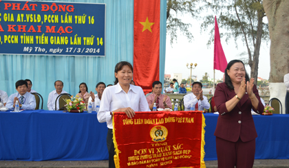 Bà Trần Kim Mai, Phó Chủ tịch UBND tỉnh trao Cờ Thi đua cùa Tổng LĐLĐ Việt Nam cho tập thể Công ty cổ phần may Sông Tiền.