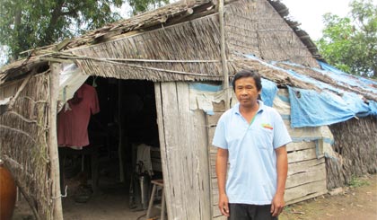 Anh Trần  Văn Lắm  trước căn nhà  không cửa  đã xuống cấp  nặng.