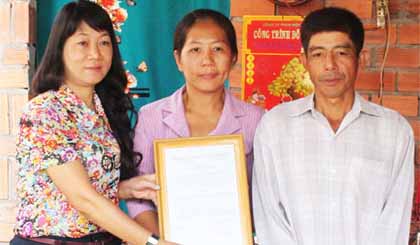 Bà nguyễn Thị Mỹ Dung, Phó Chủ tịch Thường trực  Công đoàn Viên chức TP. Hồ Chí Minh trao Quyết định tặng nhà cho gia đình ông Đinh Văn Thiện.