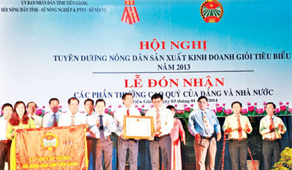 Bí thư Tỉnh ủy Trần Thế Ngọc tặng Cờ truyền thống cho Hội Nông dân tỉnh tại Hội nghị tuyên dương nông dân sản xuất kinh doanh giỏi tiêu biểu năm 2013. 							         									    Ảnh: Xuân Hòa