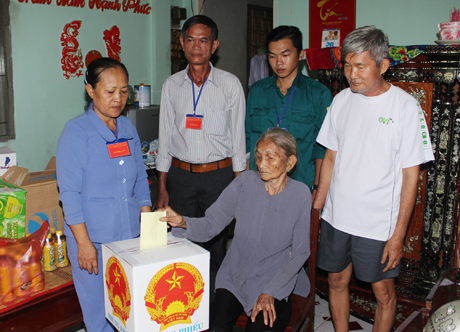 Tổ bầu cử số 1, ấp Phong Thuận, xã Tân Mỹ Chánh, TP. Mỹ Tho mang thùng phiếu phụ đến hộ bà Nguyễn Thị Hoa (91 tuổi).