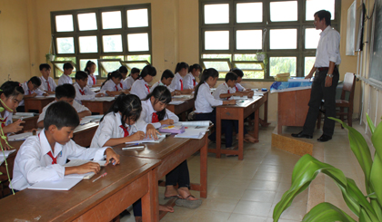 Học sinh khối lớp 8 và lớp 9  khom người viết bài do bàn ghế quá thấp.