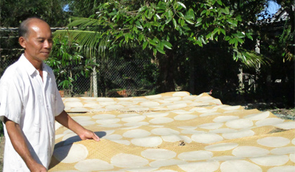 Ông Trần Văn Thiềng bên sản phẩm bánh phồng mì truyền thống của gia đình.