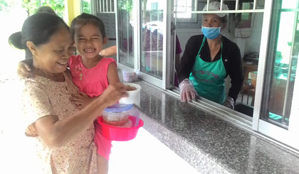 Bà Nguyễn Thị Sương cùng cháu nội nhận suất cơm trưa.