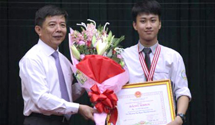 Ông Nguyễn Hữu Hoài, Chủ tịch UBND tỉnh Quảng Bình, trao bằng khen và phần thưởng cho em Nguyễn Thế Quỳnh. Ảnh: VGP