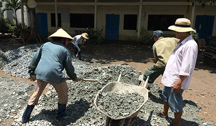Công nhân xây dựng Trường Tiểu học Long Hòa, TP. Mỹ Tho làm việc luôn cả buổi trưa để cố gắng hoàn thành các hạng mục còn lại. 