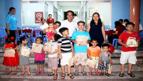 Ông Phạm Văn Sơn, Phó Tổng Biên tập Báo Ấp Bắc (giữa) trao quà cho con em cán bộ viên chức, phóng viên