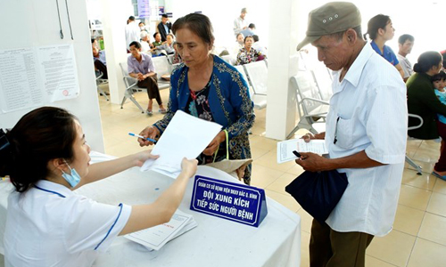 Nhân viên y tế hướng dân người bệnh làm thủ tục khám chữa bệnh. (Ảnh: Dương Ngọc/TTXVN)
