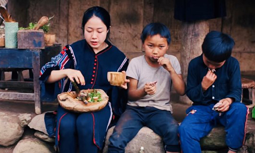 Vương Anh cùng trẻ em bản địa thưởng thức món bồ câu nướng vừa nấu tại Tủa Châu - Điện Biên (Ảnh cắt từ clip)