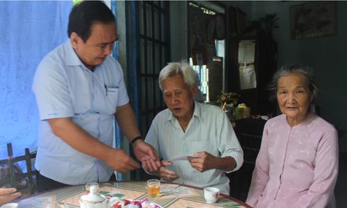 Phó Bí thư Thường trực Tỉnh ủy Võ Văn Bình trao quà cho ông Phạm Văn Ba (thương binh 61%), ngụ ấp Hòa, xã Hòa Hưng. 