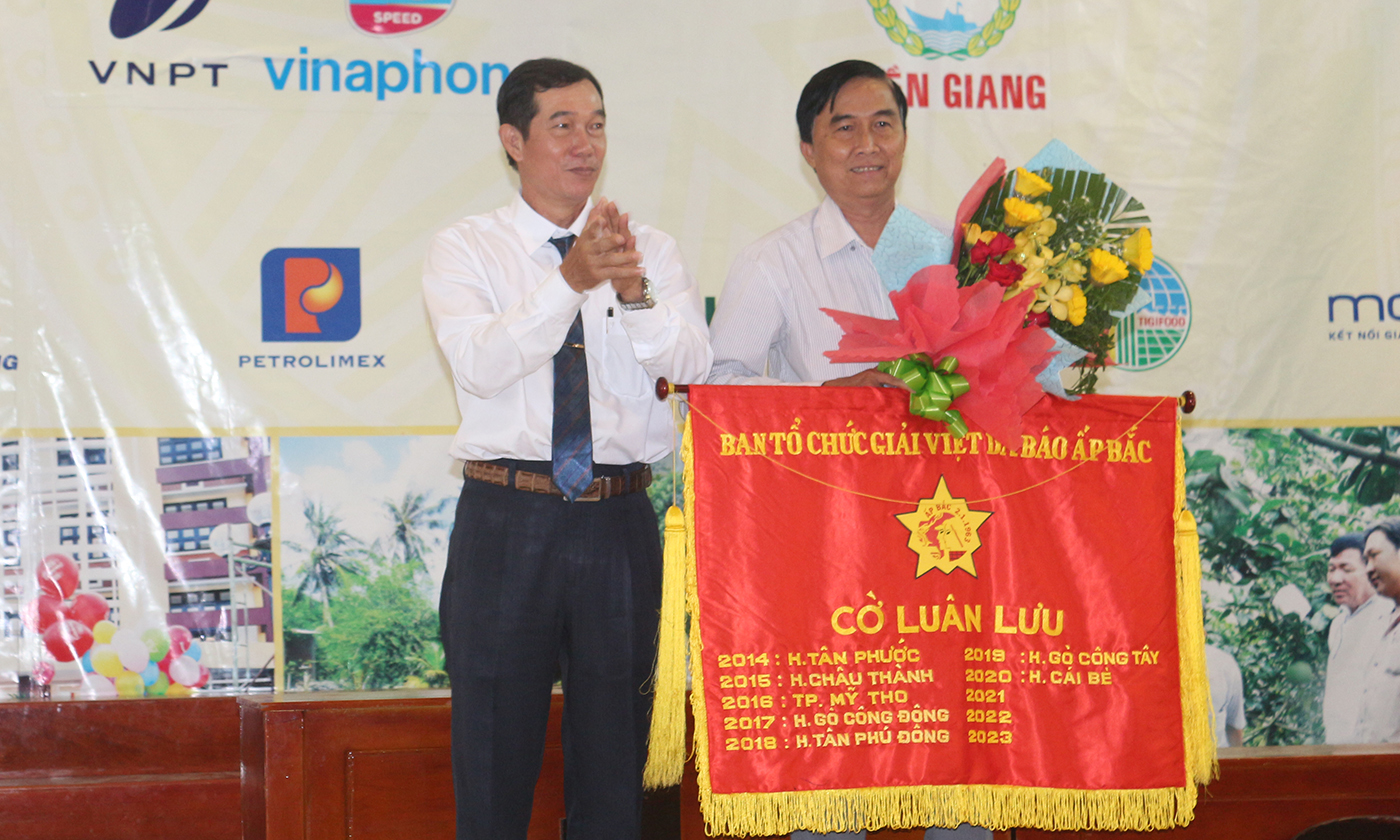 Đại diện lãnh đạo UBND huyện Gò Công Tây trao cờ luân lưu cho UBND huyện Cái Bè - đơn vị đăng cai Giải Việt dã Báo Ấp Bắc lần thứ 37 - năm 2020. Ảnh: HỒNG LÊ