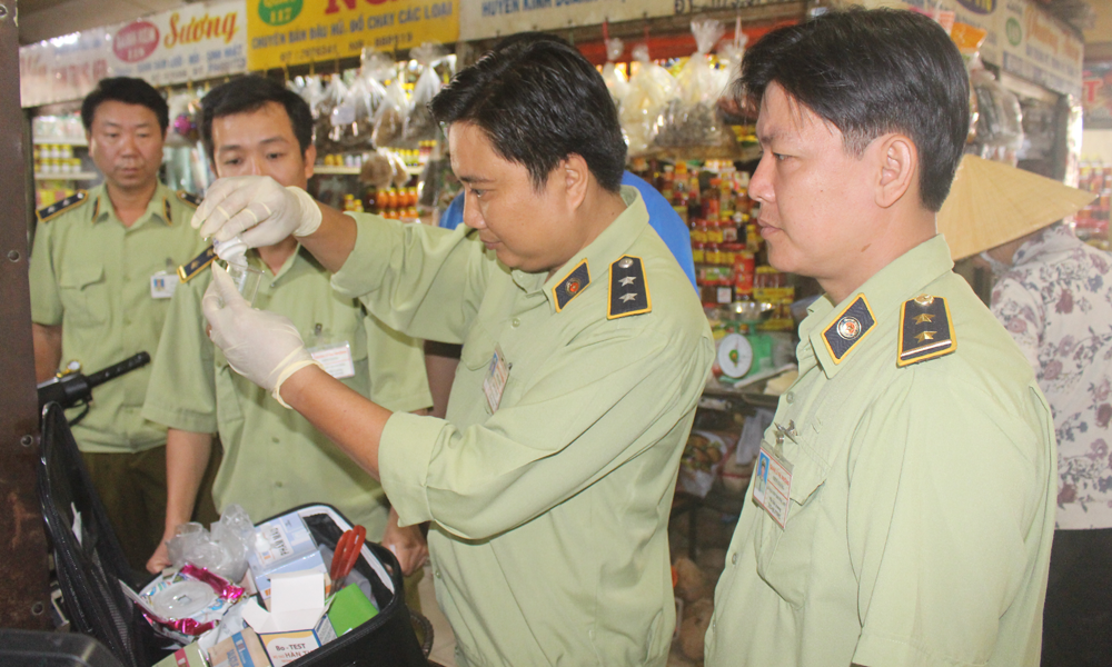 Lực lượng chức năng tiến hành test nhanh các mẫu thực phẩm tại chợ.