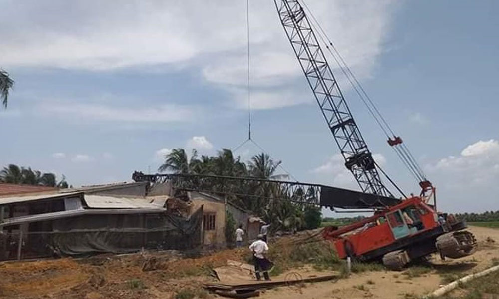 Hiện trường vụ xe cần cẩu ngã đè nhà dân.