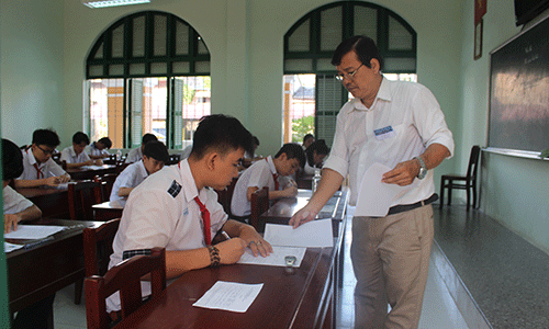 Giám thị phát giấy thi cho thí sinh. 