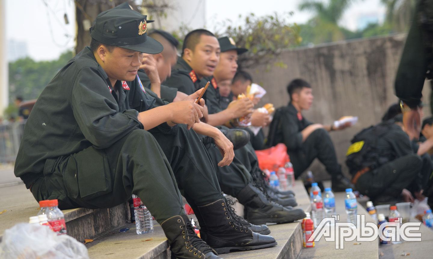 Các chiến sĩ Cảnh sát cơ động tranh thủ chuyền nhau những ổ bánh mì, chay nước trước trận đấu.