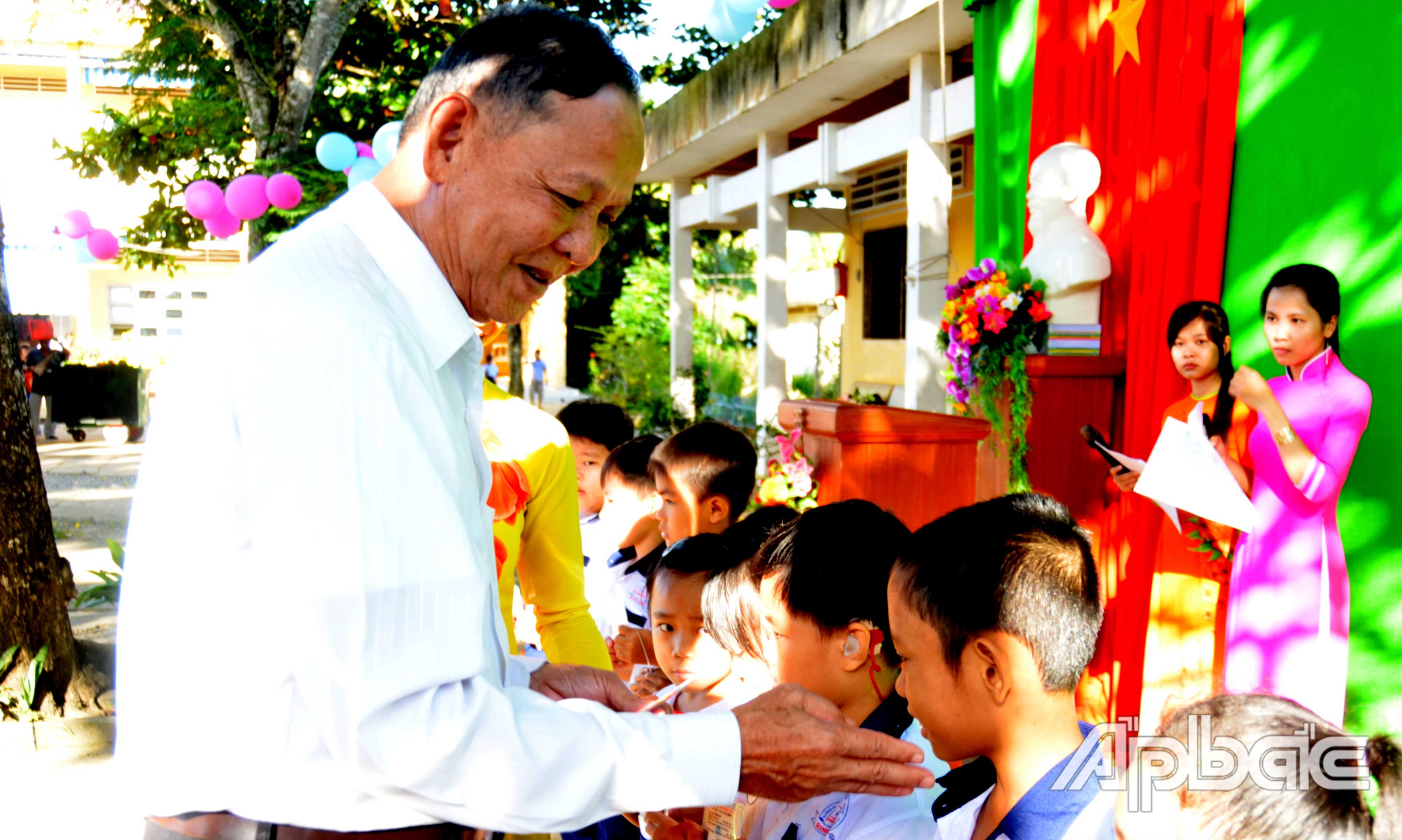 Trung tướng Nguyễn Việt Thành trao thẻ bảo hiểm y tế cho học sinh có hoàn cảnh  khó khăn của Trường Tiểu học Thanh Bình.                                                Ảnh: HỒNG PHƯỢNG 