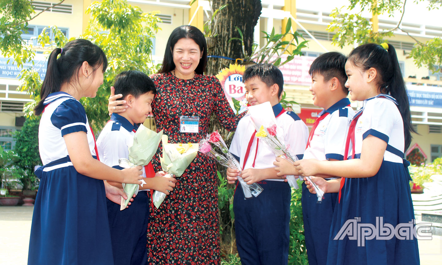 Học sinh Trường Tiểu học Thiên Hộ Dương (TP. Mỹ Tho) tặng hoa chúc mừng cô giáo nhân ngày Nhà giáo Việt Nam.               		                                                                                                          Ảnh: PHI CÔNG
