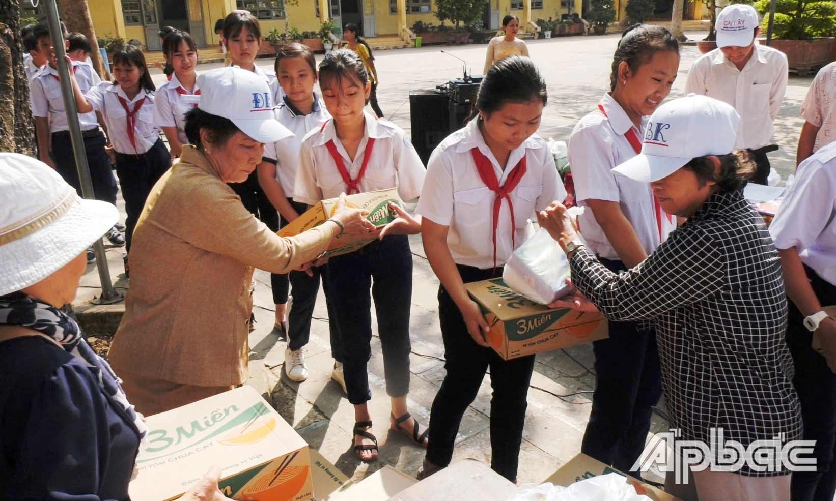  Cô Bé (bên trái) trong đợt tặng quà cho học sinh có hoàn cảnh khó khăn tại Trường THCS Tam Bình (huyện Cai Lậy).