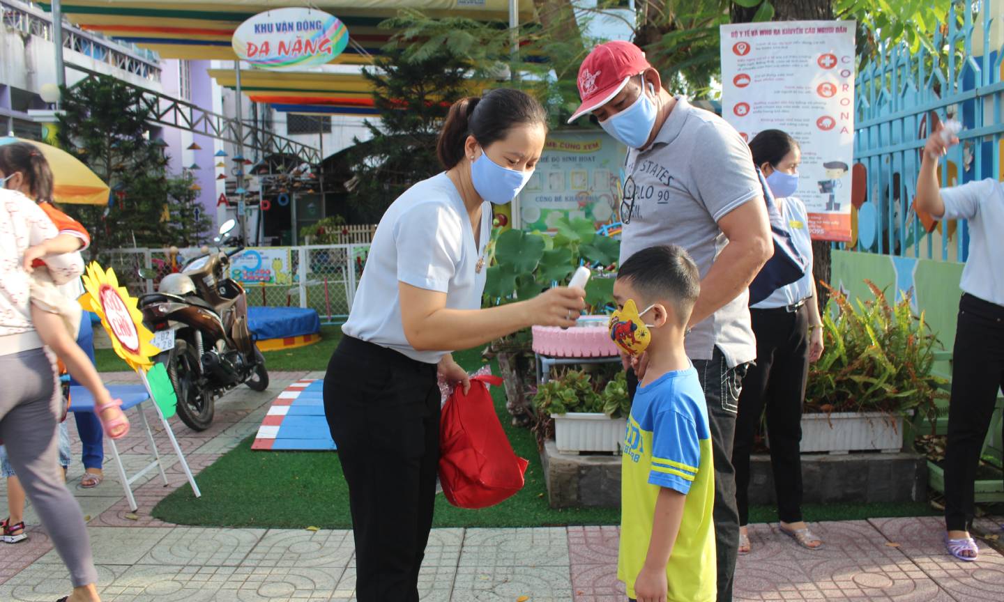 Đo thân nhiệt cho trẻ.