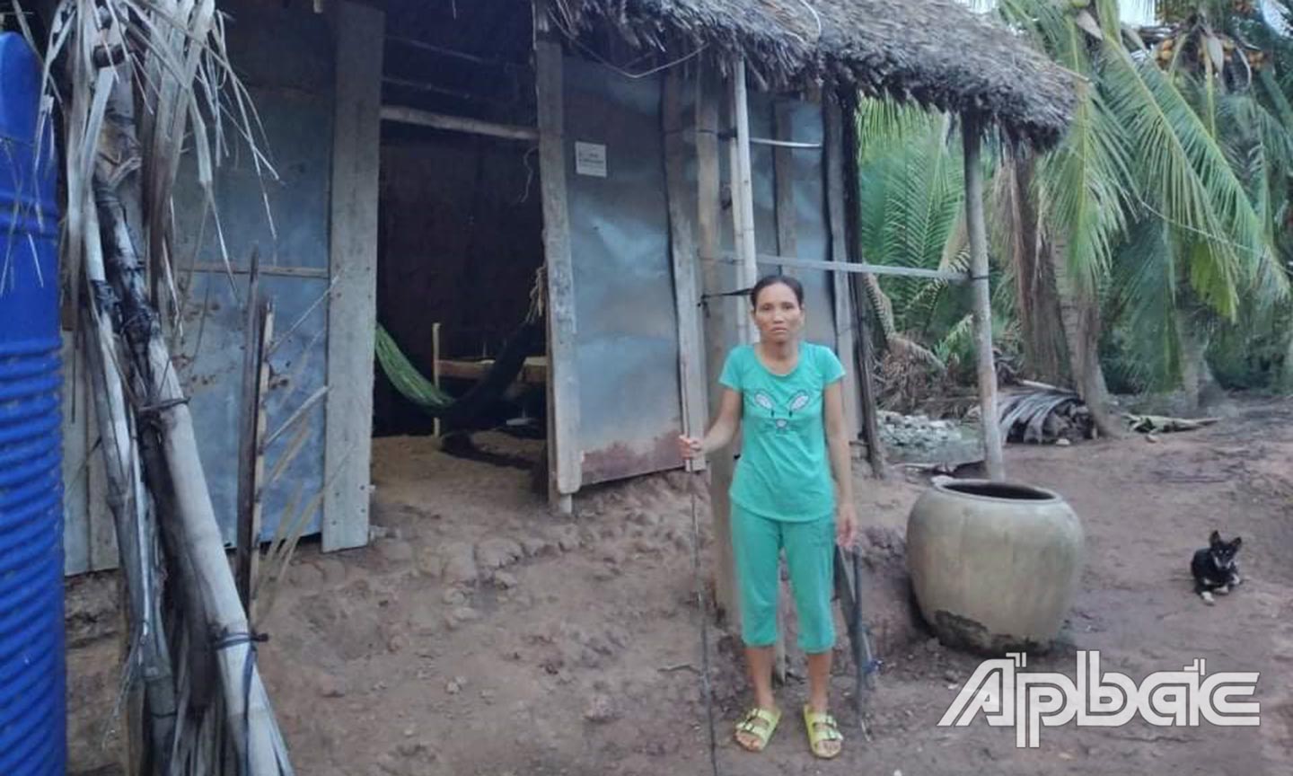 Chị Sự trước  căn nhà  rách dột  của mình.