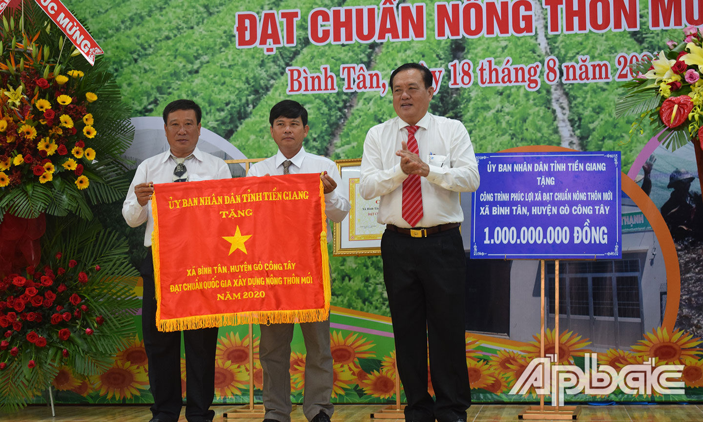 Đồng chí Lê Văn Nghĩa trao Cờ thi đua của UBND tỉnh cho xã Bình Tân.