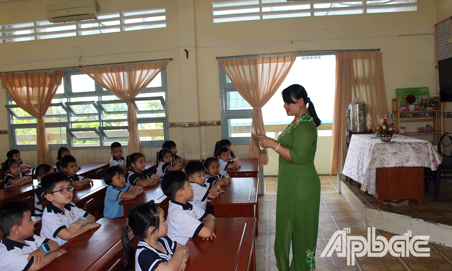 Học sinh lớp 1 lắng nghe cô giáo dặn dò. 