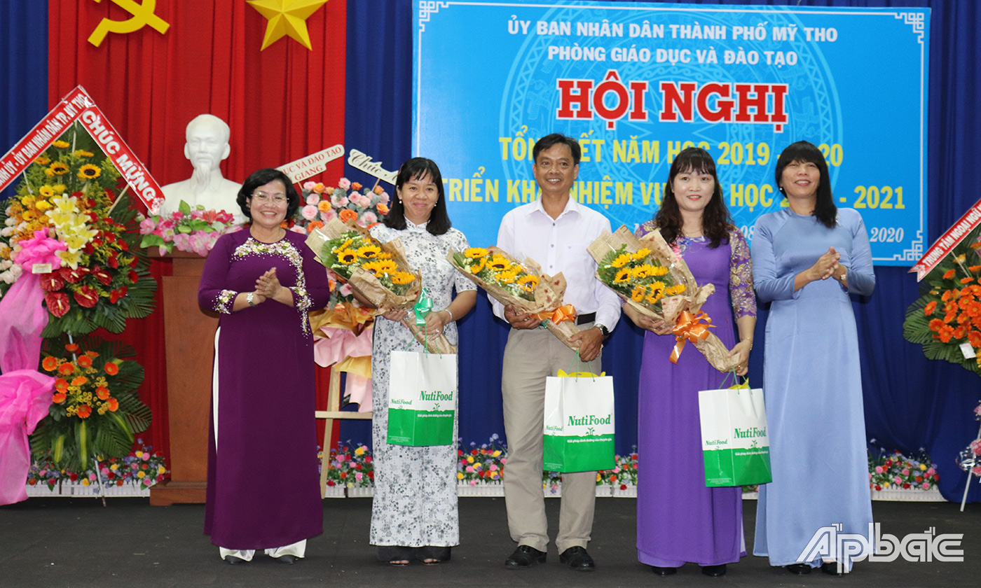 Đồng chí Lê Thị Bé Phượng, Phó Chủ tịch UBND TP. Mỹ Tho trao hoa chúc mừng Hiệu trưởng mới được bổ nhiệm.