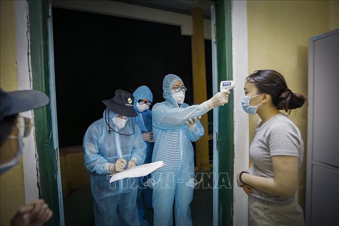 Bác sỹ lên từng phòng để đo thân nhiệt và lấy thông tin của từng người được đưa về điểm cách ly tập trung theo dõi COVID-19. Ảnh: Trọng Đạt/TTXVN