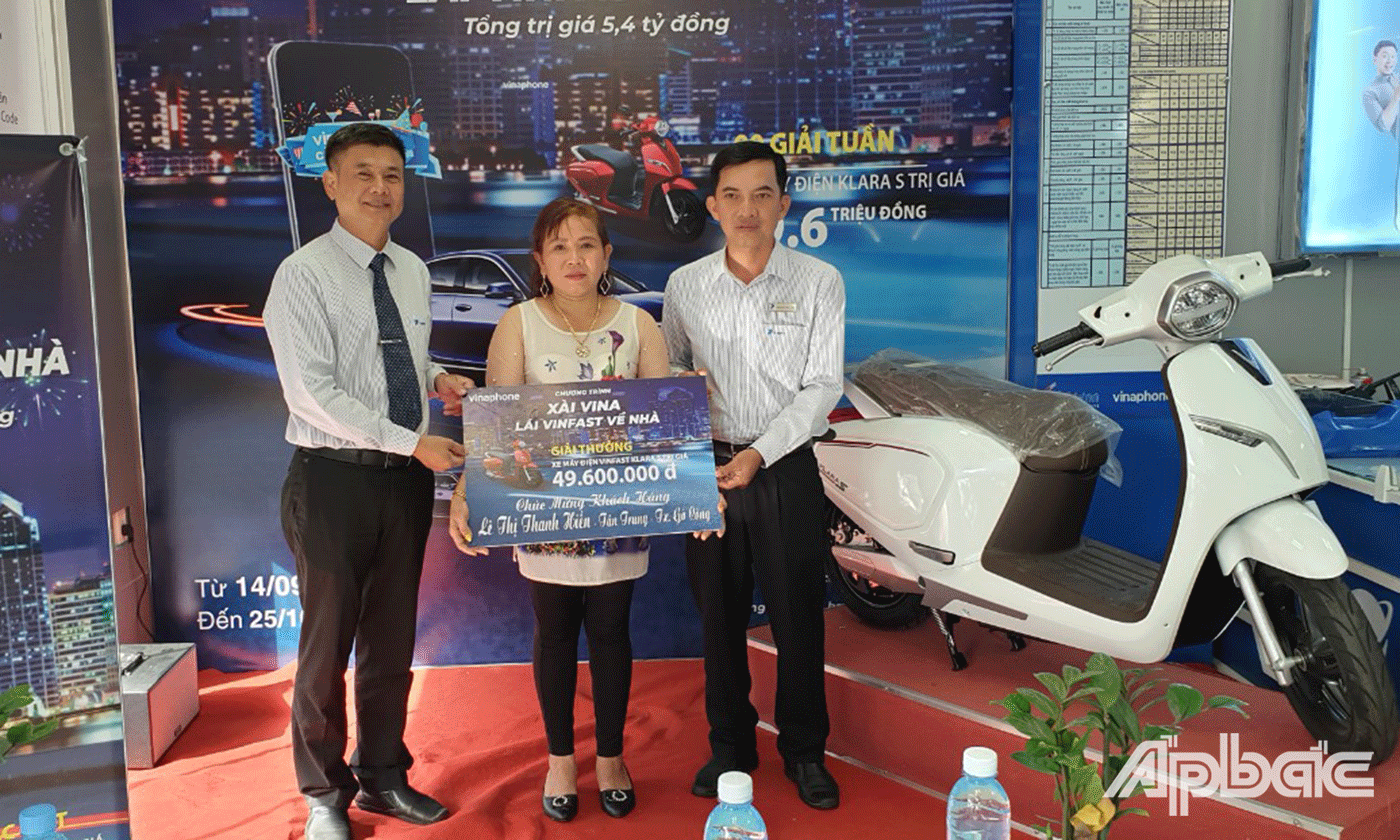 (Ông Trịnh Quốc Khánh - GD VNPT-VinaPhone Tiền Giang & Ông Nguyễn Phục Ân - GĐ VinaPhone TX Gò Công trao thưởng cho khách hàng Lê Thị Thanh Hiền)