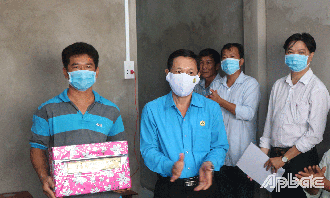 Đồng chí Lê Minh Hùng Chủ tịch Liên đoàn Lao động tỉnh Tiền Giang trao quà, chúc mừng anh Thắng có được ngôi nhà mới 