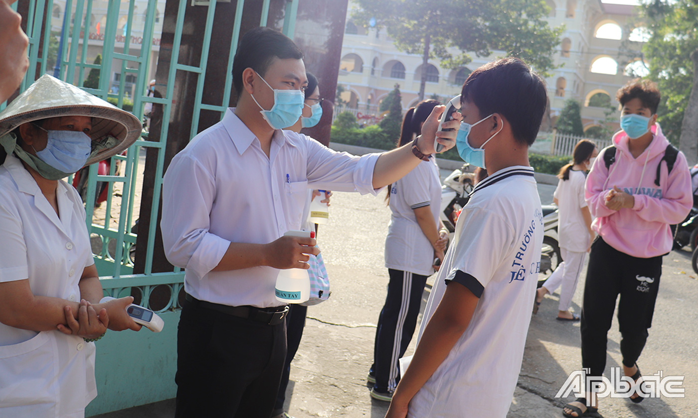 Các thí sinh được đo thân nhiệt, rửa tay sát khuẩn trước khi vào phòng thi.