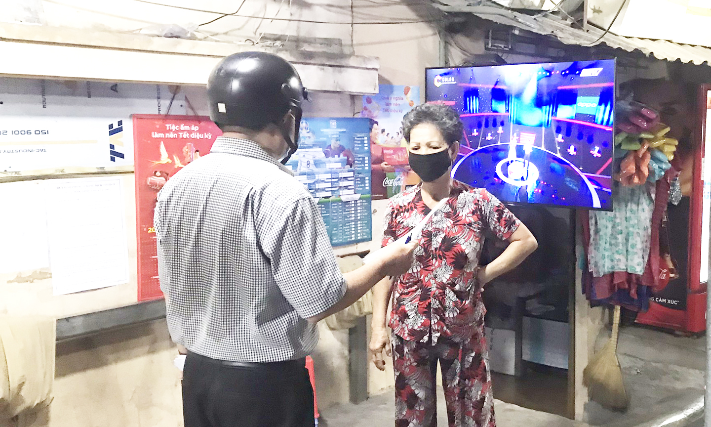 Cán bộ cơ quan chức năng triển khai quy định về giãn cách để phòng, tránh Covid-19 cho tiểu thương