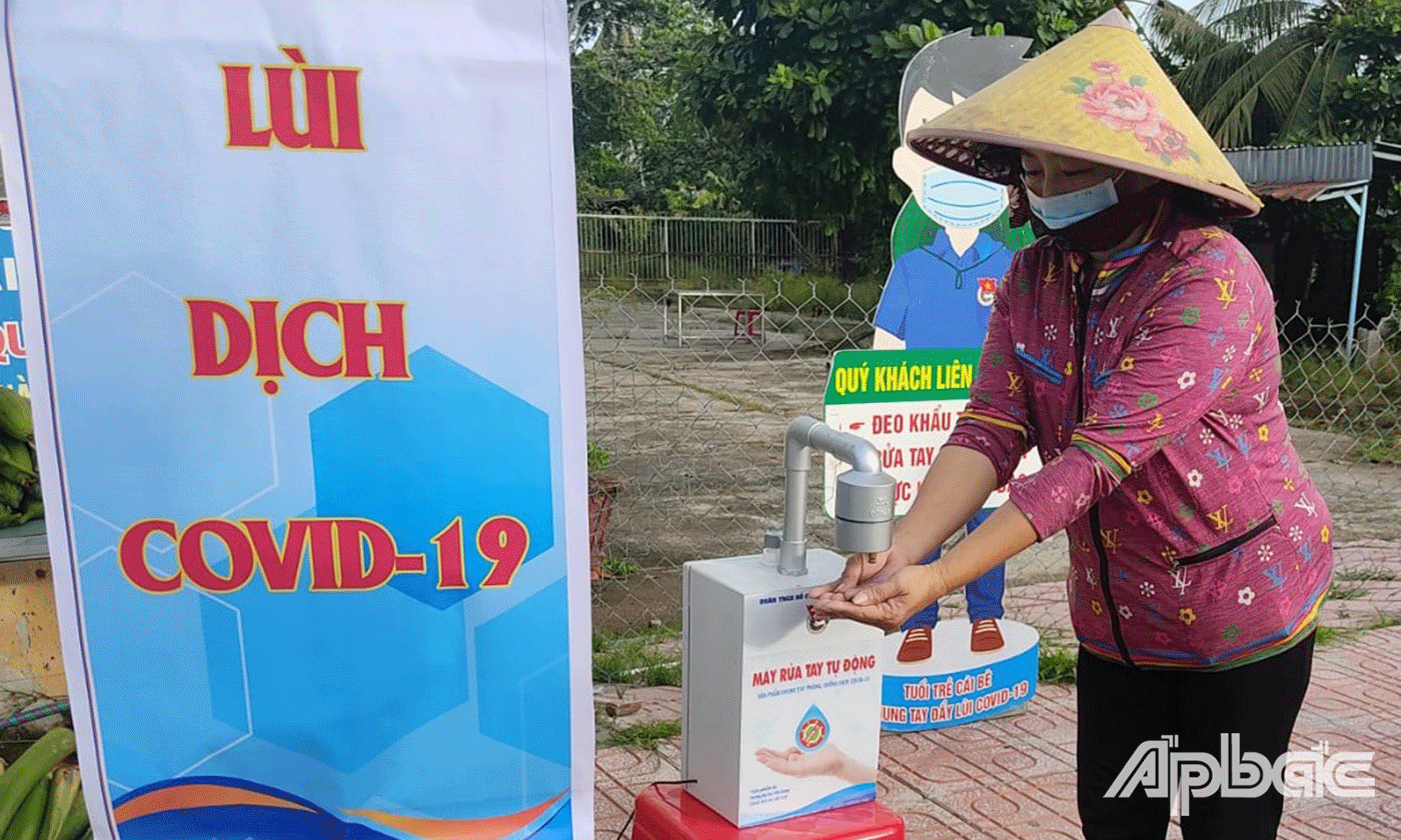 Người dân rửa tay sát khuẩn trước khi nhận quà hỗ trợ