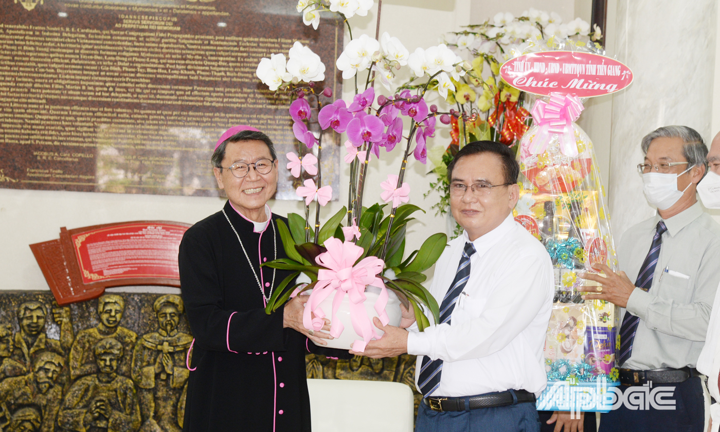 đồng chí Võ Văn Bình, Phó Bí thư Thường trực Tỉnh ủy, Chủ tịch HĐND tỉnh Tiền Giang trao hoa chúc mừng Giám mục Nguyễn Văn Khảm