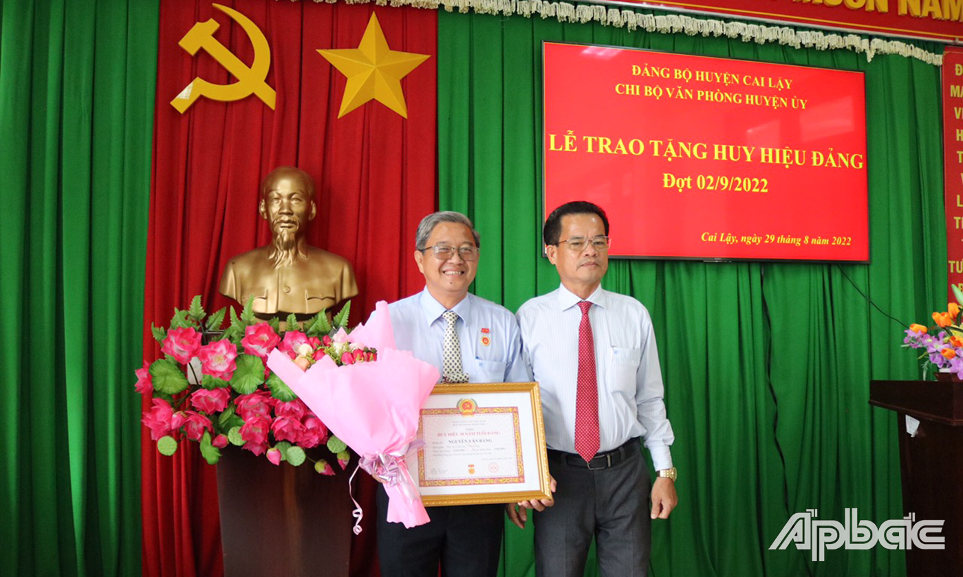 Ông Trương Văn Rất, Phó Bí thư Thường trực Huyện ủy Cai Lậy trao Huy hiệu 30 năm tuổi Đảng cho ông Nguyễn Văn Bằng.