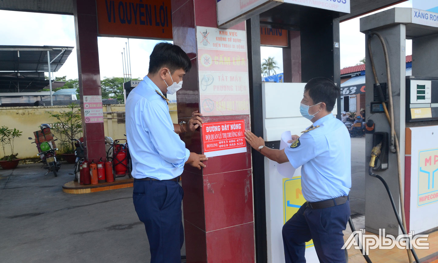 Lực lượng QLTT kiểm tra các cửa hàng kinh doanh xăng, dầu và dán số điện thoại đường dây nóng.