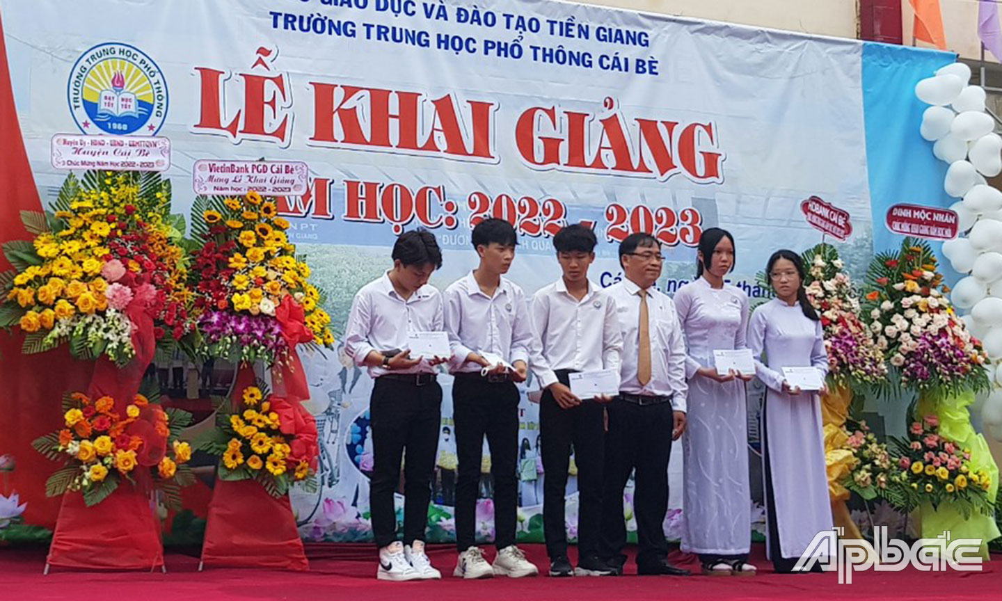 Ông Nguyễn Hữu Phước – Phó phụ trách phòng giao dịch Cái Bè (đứng thứ 3 từ phải sang) trao học bổng tại trường THPT Cái Bè, huyện Cái Bè, Tiền Giang)