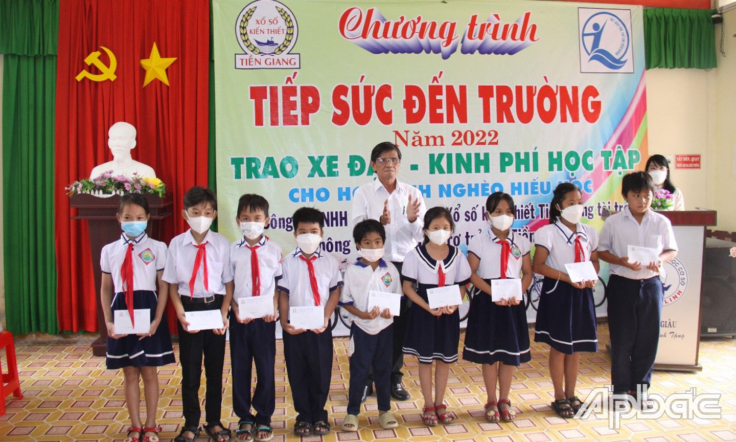 Ông Phạm Văn Đức, Phó Trưởng phòng Tổ chức - Hành chính Công ty TNHH MTV Xổ số kiến thiết Tiền Giang trao quà cho các em học sinh.