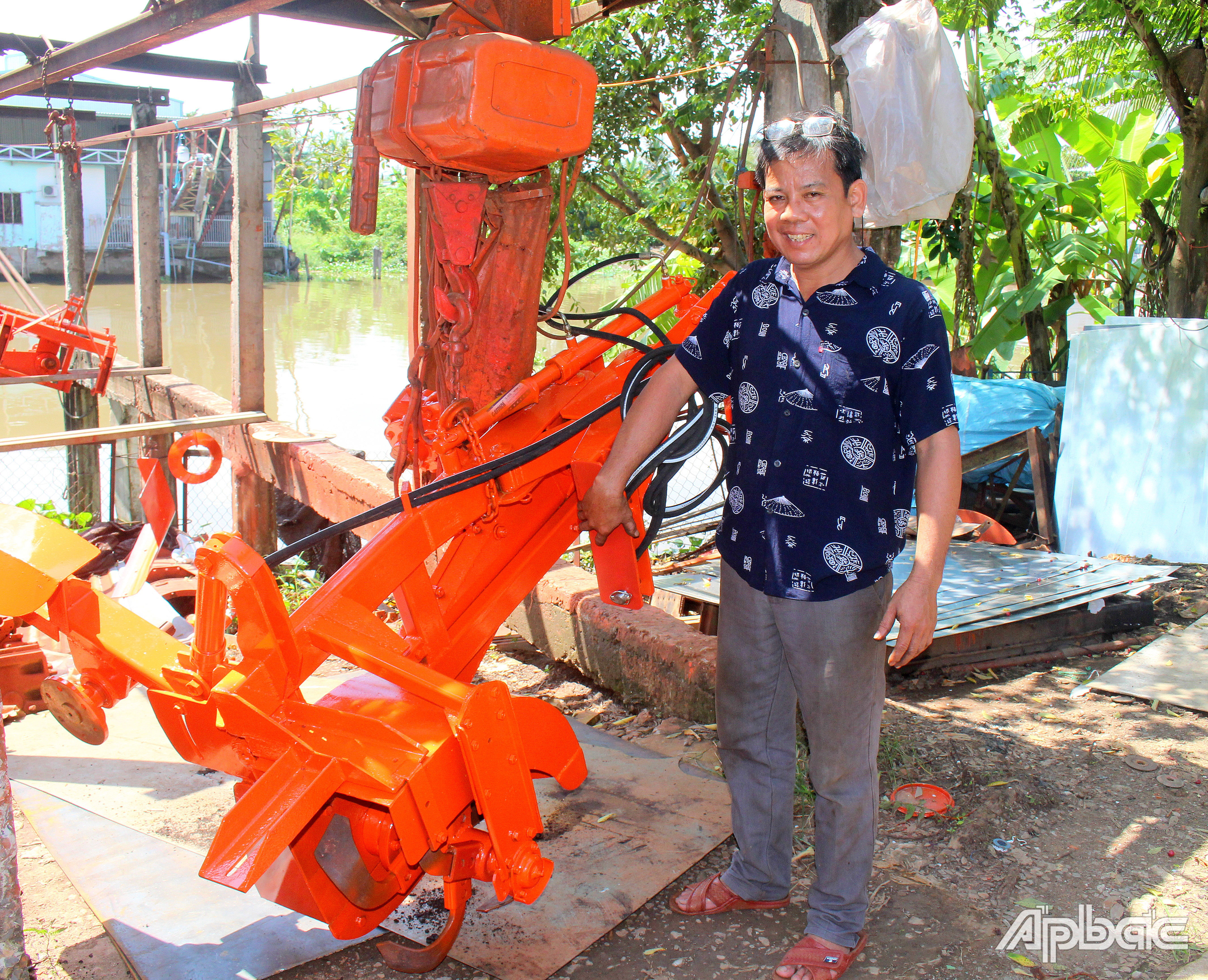 Anh Thái bên cạnh sản phẩm nông cụ cải tiến do anh phát minh.