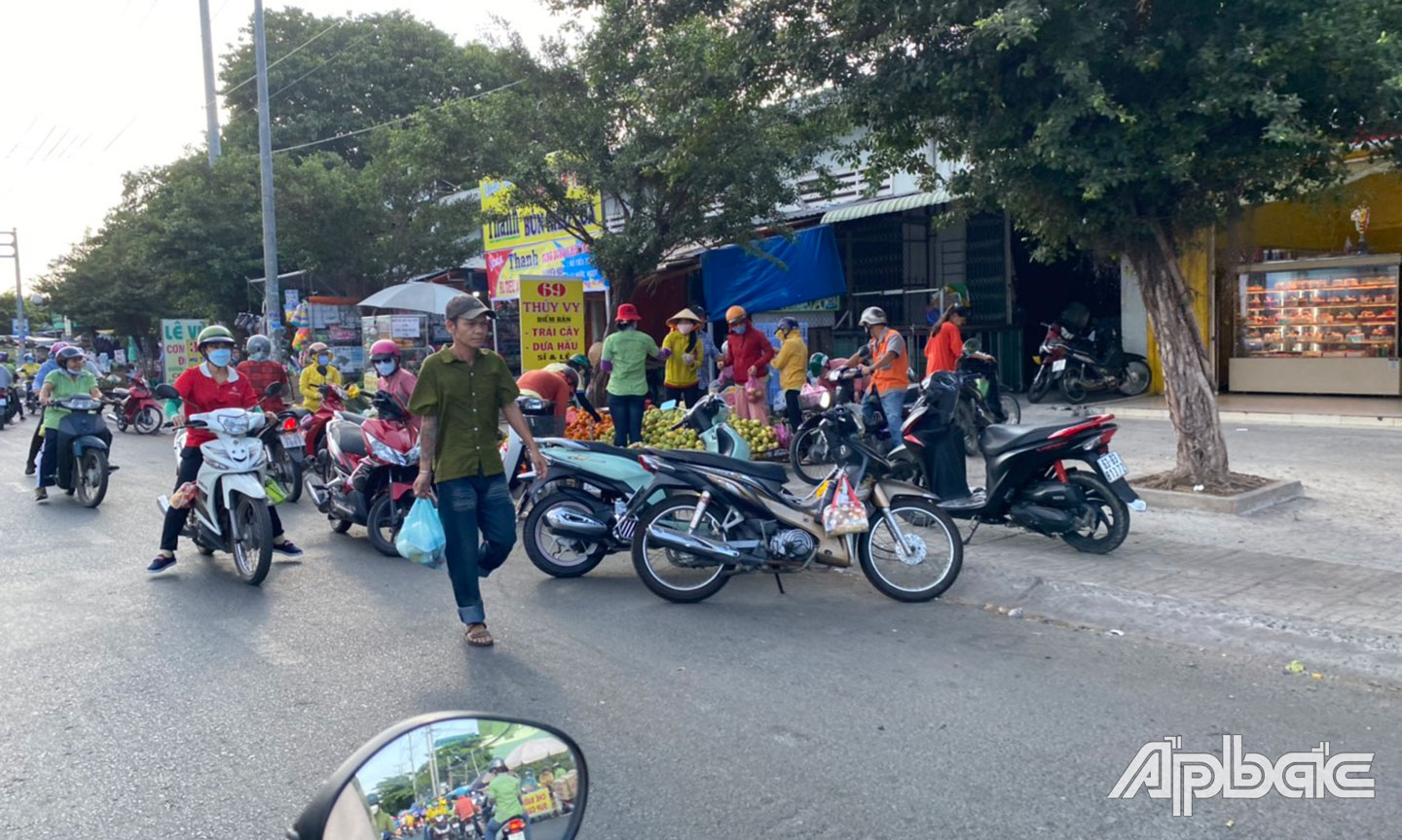 Lấn chiếm lòng lề đường để mua bán, buộc người đi bộ đi ra phần đường xe cơ giới tại chợ Trung An (TP. Mỹ Tho).