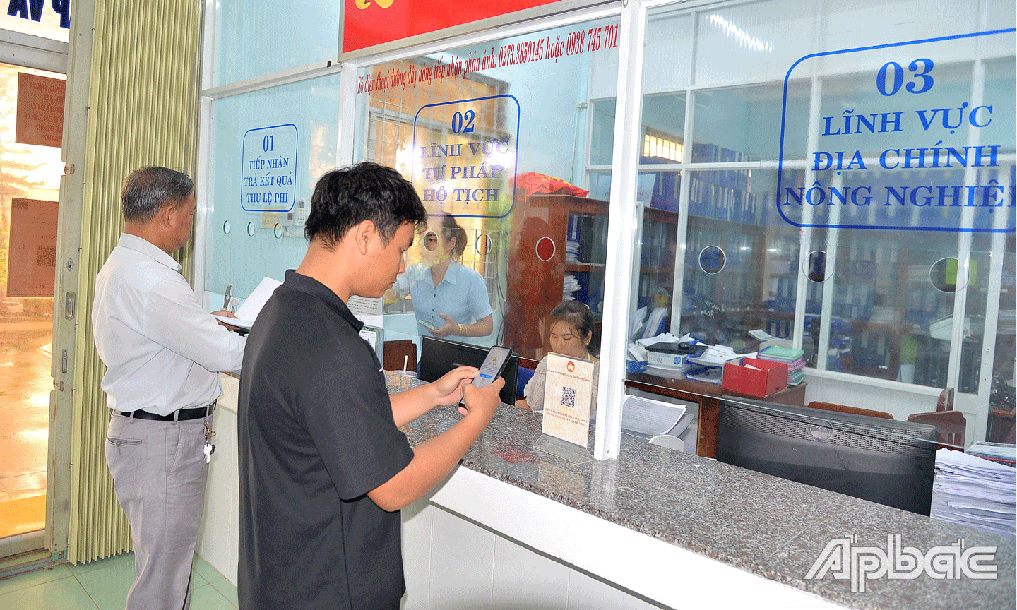Người dân thực hiện thủ tục hành chính tại Bộ phận tiếp nhận và trả kết quả xã Tân Mỹ Chánh.              Ảnh: VĂN THẢO