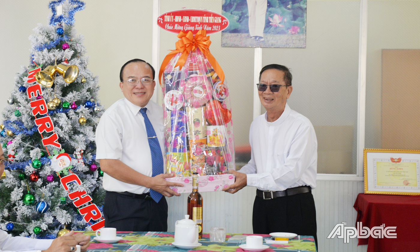 Đồng chí Nguyễn Chí Trung trao quà chúc mừng Giáng sinh đến Linh mục Trương Quý Vinh, Chủ tịch Ủy ban Đoàn kết Công giáo tỉnh.