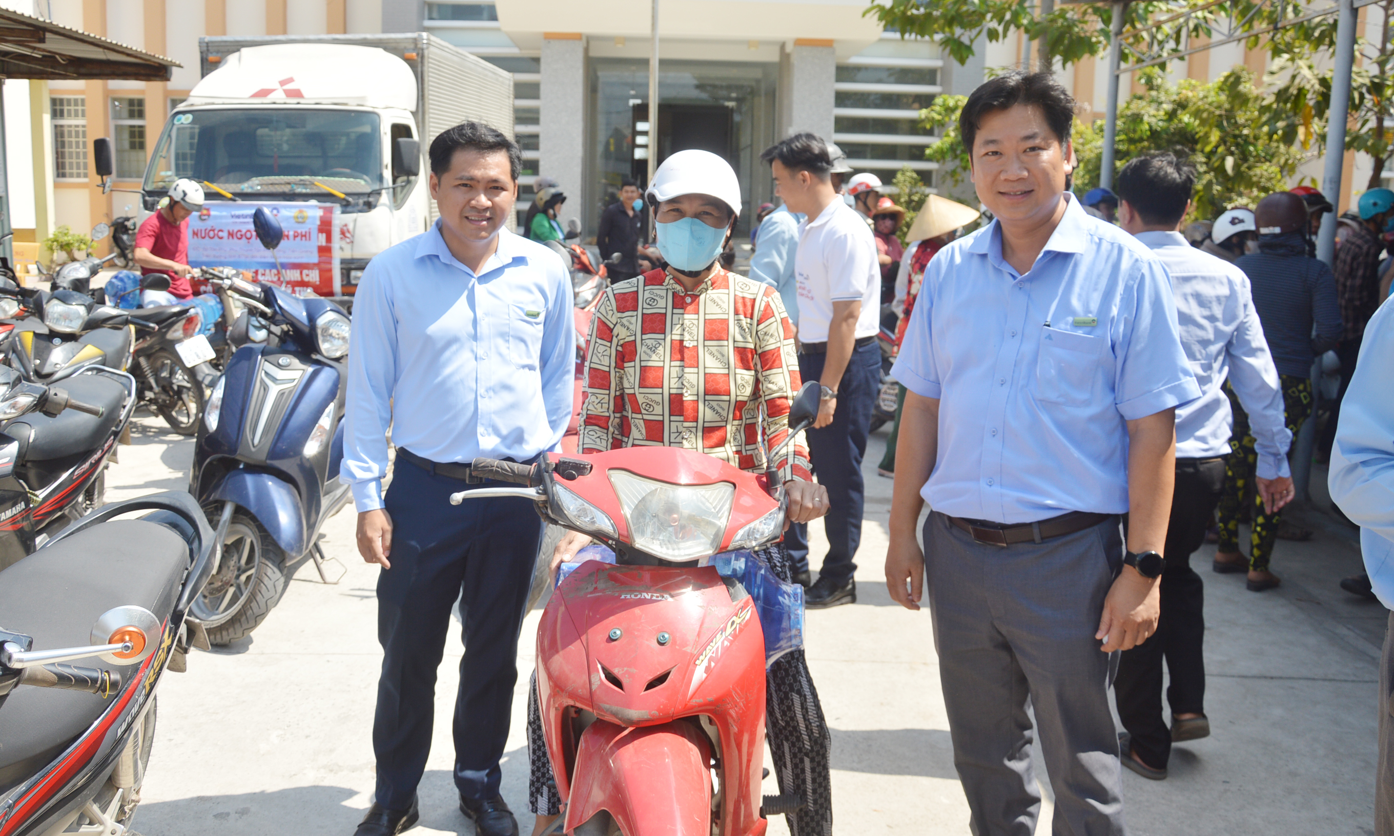 Người dân vận chuyển các bình nước uống được hỗ trợ về nhà.