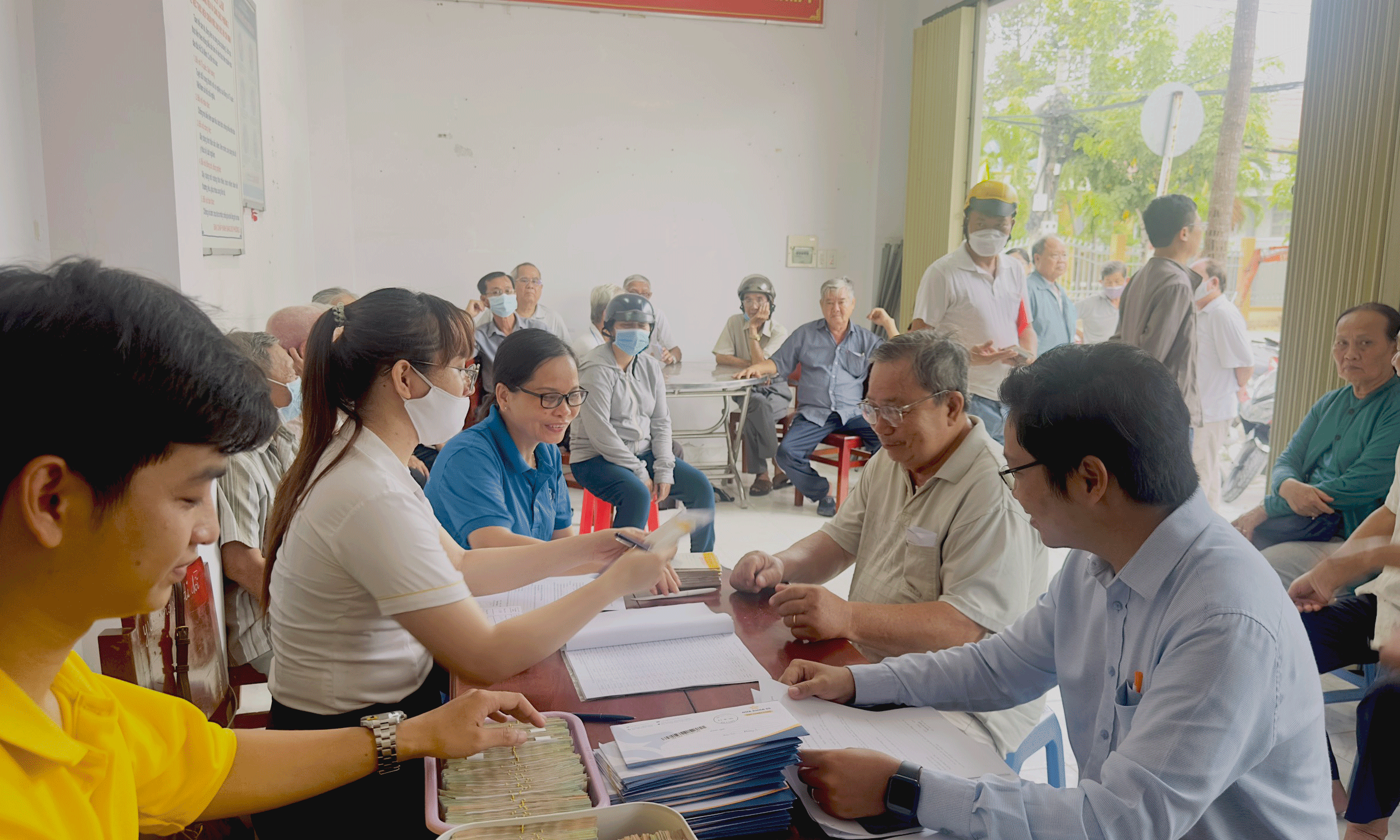 Viên chức BHXH tỉnh vận động người hưởng lương hưu nhận tiền qua tài khoản cá nhân ATM tại điểm chi trả phường 5 TPMT