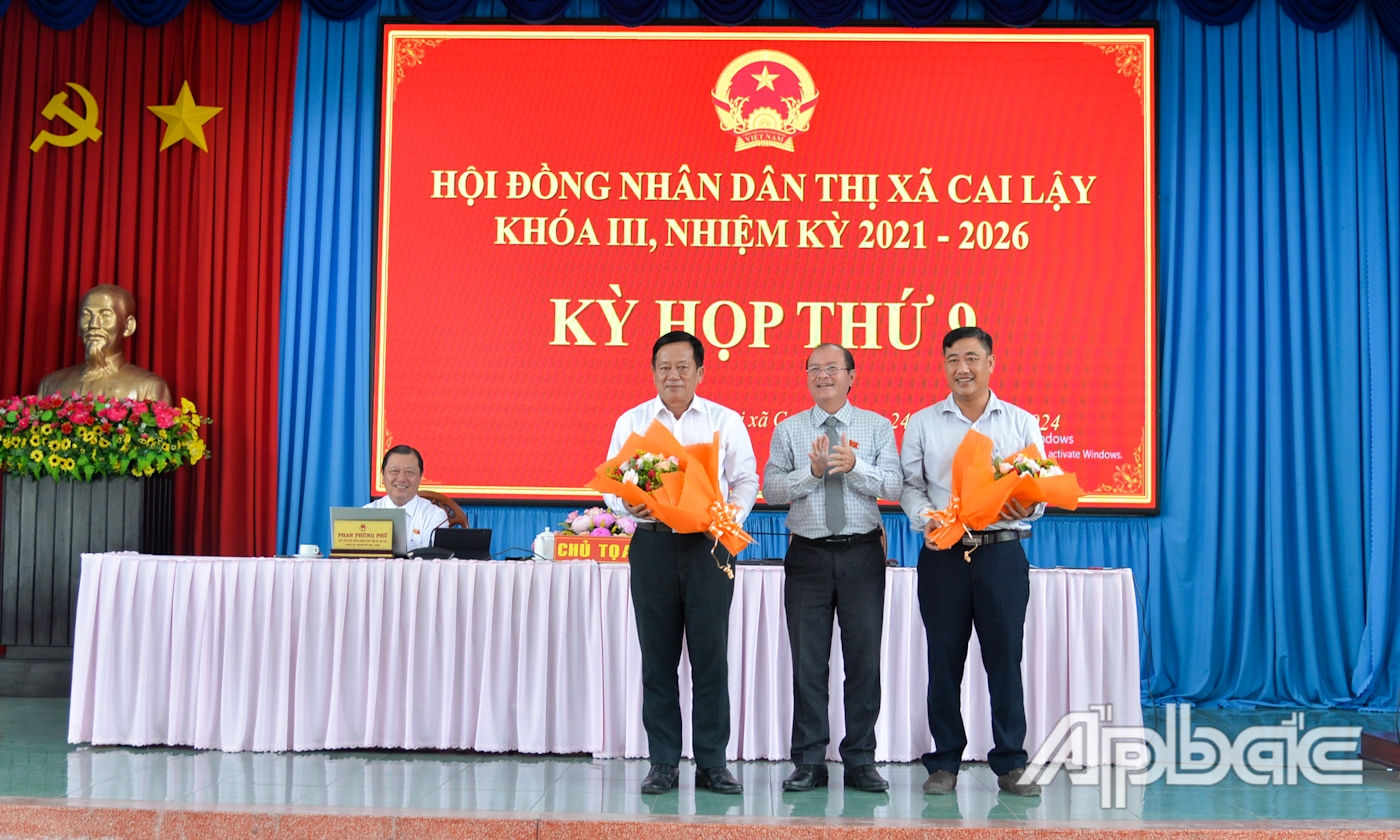Chủ tịch UBND TX. Cai Lậy Trần Văn Thức tặng hoa chúc mừng các đồng chí được bầu Ủy viên UBND thị xã khóa III, nhiệm kỳ 2021 - 2026.