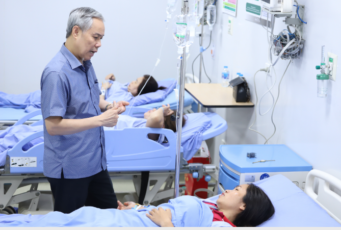 TS Nguyễn Hùng Long - Phó Cục trưởng Cục An toàn thực phẩm, Bộ Y tế hỏi thăm công nhân trong vụ ngộ độc thực phẩm xảy ra tại Công ty TNHH Shinwon Ebenezer Việt Nam (Vĩnh Phúc). Ảnh: Thành Long